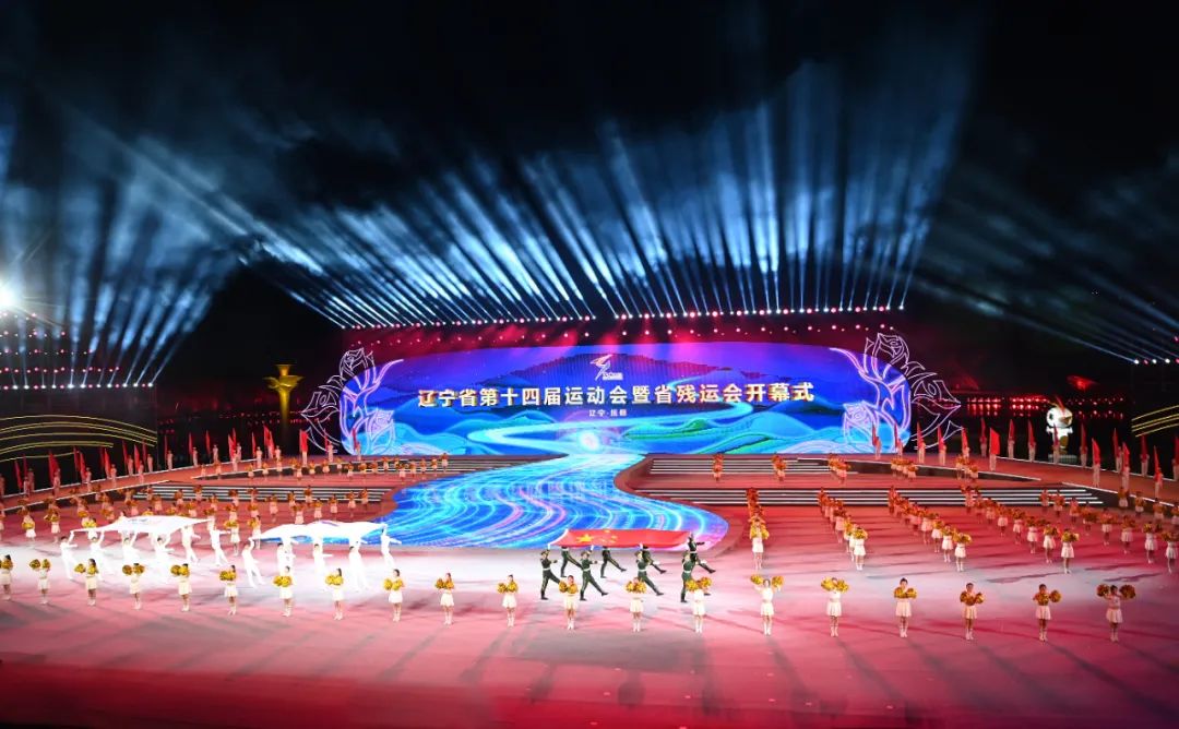 在辽宁省第十四届运动会暨省残运会开幕式上，仪仗队员护拥着五星红旗通过主席台。