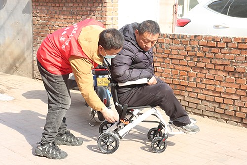 图为市残联志愿者为肢体残疾人适配轮椅