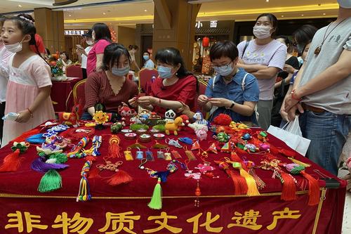 图为非物质文化遗产传承人金慧敏现场传授绳结技艺