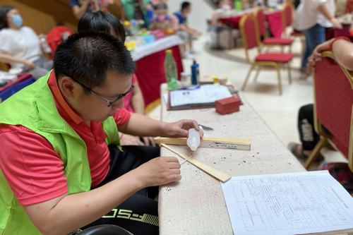图为自闭症儿童现场制作手工折扇