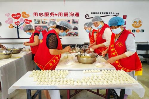 图为志愿者为盲人朋友包饺子
