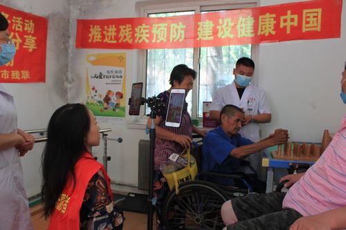 图为骨科医院李医生指导肢体残疾人进行康复训练