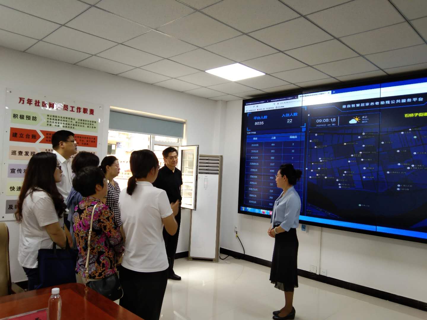 图为调研组调研锦州市凌河区石桥子街道万年社区残疾人智慧居家托养网格管理工作