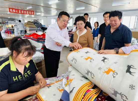 图为走访残疾人就业扶持点